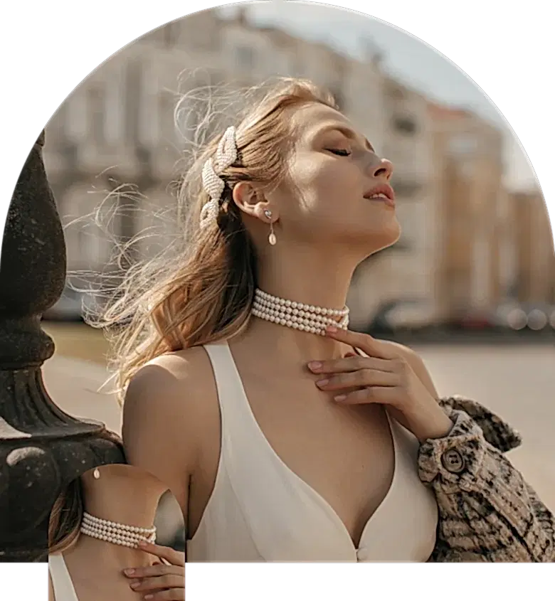 Bir kadın inci gerdanlık ile poz veriyor.