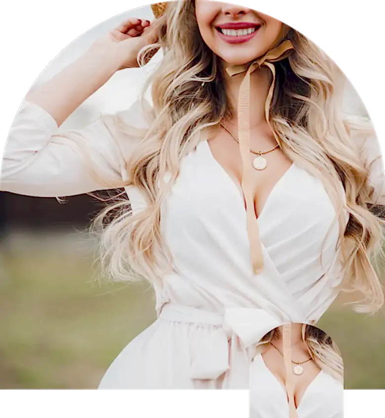 Beyaz bir elbise ve şapka giyen bir kadın poz veriyor.