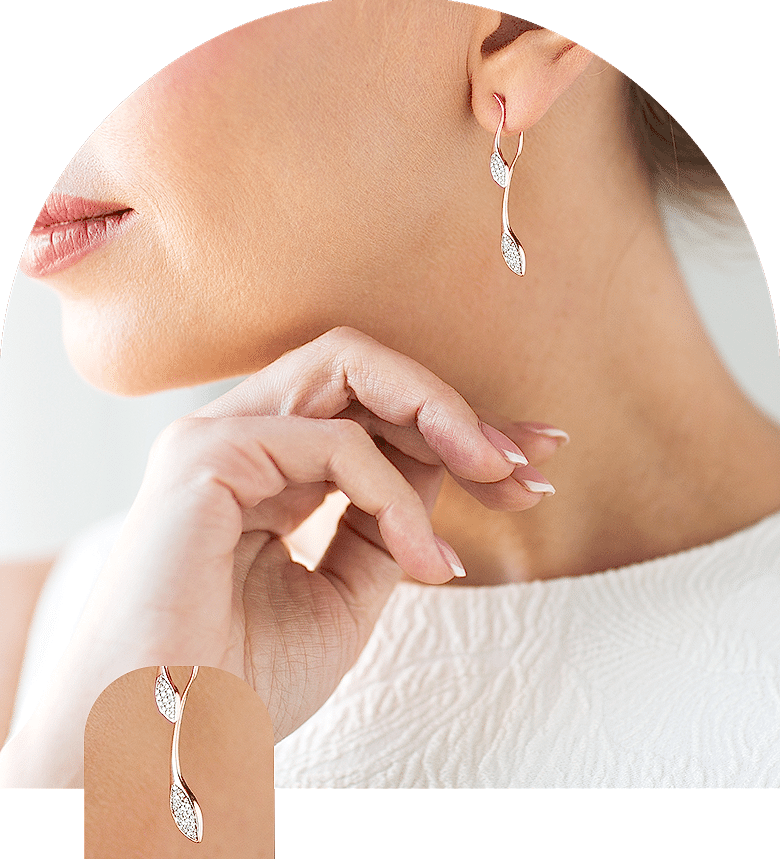 Yaprak tasarımlı bir çift Gümüş küpe takan bir kadın.