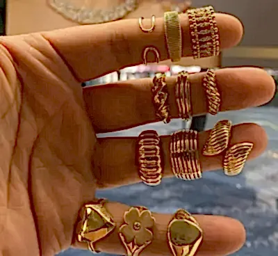 Altın yüzüklerle süslenmiş bir kişinin eli.